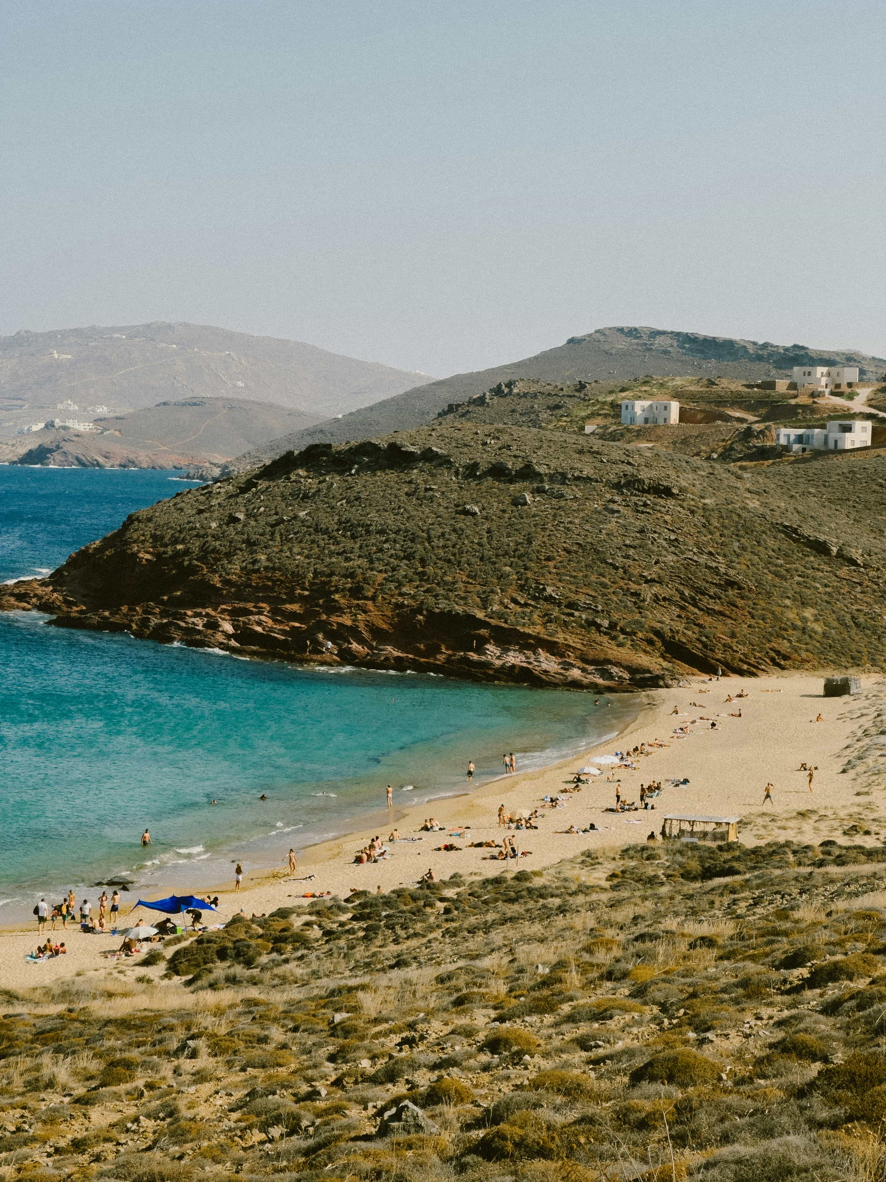 A sandy cove on the north coast of Mykonos, framed by dry rocky hills